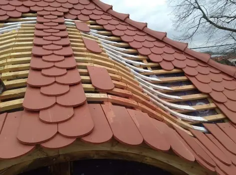 Krycie dachu dachówką ceramiczną karpiówką - wole oko w trakcie montażu